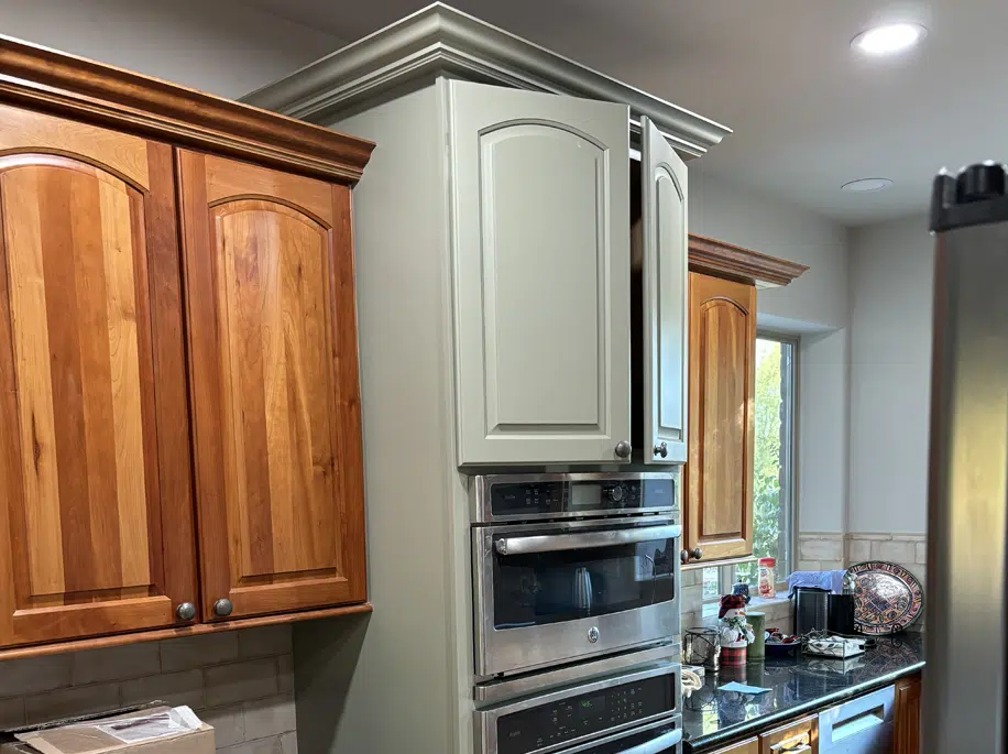 Cabinet Refinishing Before and After Tucson Wood kitchen cabinets partially refinished to light gray, showing a before-and-after transformation by Red Door Painting Pros in Tucson.